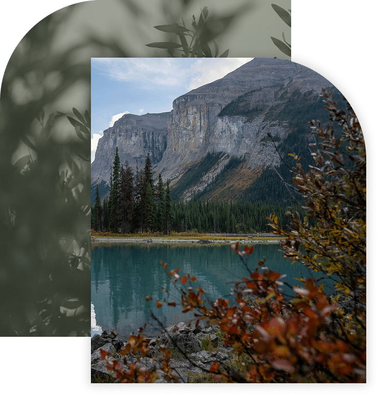Mountain lake with evergreen trees and rocky cliffs in the background