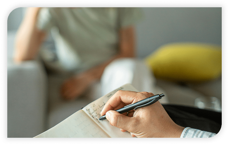 Therapist taking notes during a counseling session.