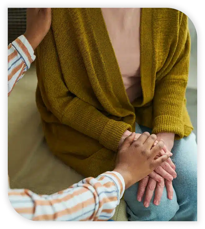 Person consoling another with a hand on their shoulder.